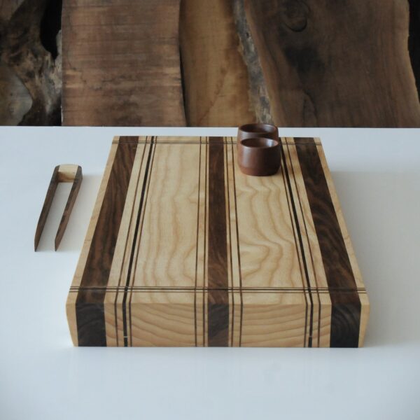 a wooden cutting board with a pair of rings on top