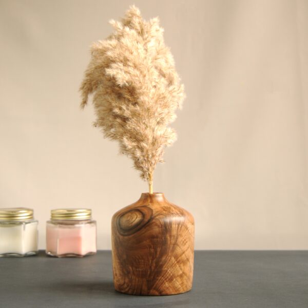 a wood vase with a plant in it